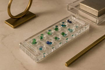 Lucite Mancala game styled on marble table with modern brass decor accents