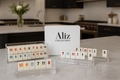 Lucite Rummikub game fully displayed with Aliz Collection packaging box in background